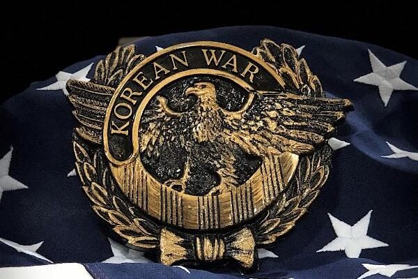 Korean War U.S. Veteran marker with an eagle design displayed on an American flag background