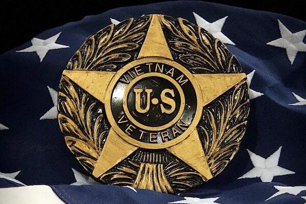 Vietnam War U.S. Veteran star-shaped marker displayed on an American flag background