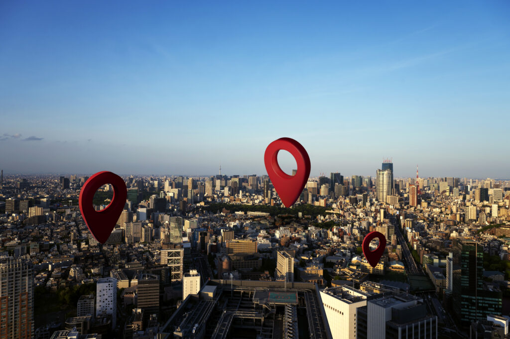 Red location pin icons placed against a city background, symbolizing geographic distribution or mapping.