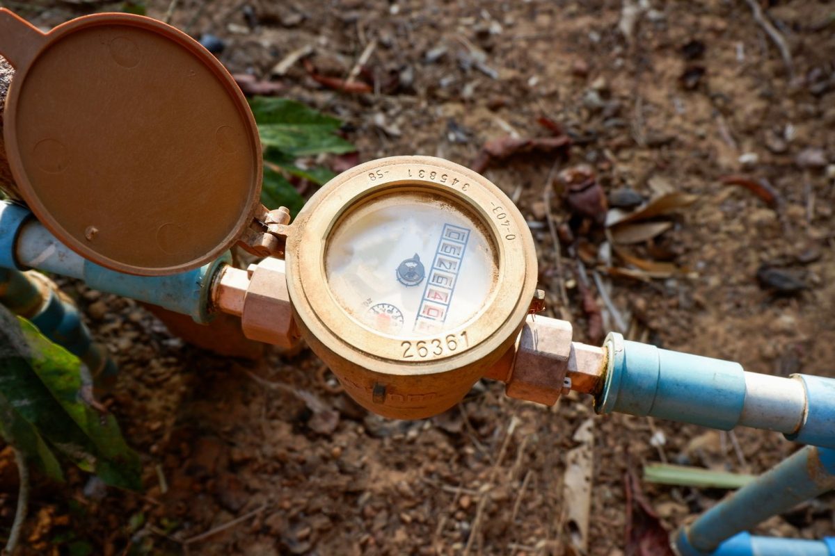 Water flow meter types showing brass positive displacement meter installed on blue water pipes